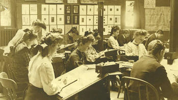 students work at drawing tables in a black-and-off white photo