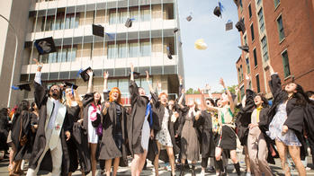 2021 graduates tossing their hats