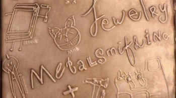 title of show engraved in a slab of copper
