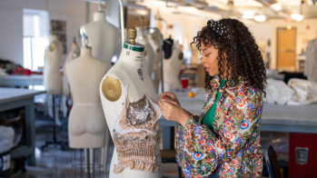 Student working in an apparel studio draping fabric