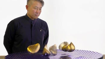 the artist looking at objects that appear to be floating in space