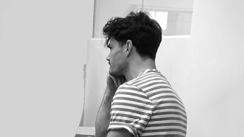 Jason Connell facing away from the camera, sitting in a chair