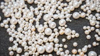 a pile of pearls on a black tray