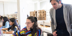 Assistant Professor Stefano Corbo looks at students' work in an Interior Architecture studio