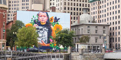Still Here, a 100- x 120-foot mural celebrating Rhode Island’s indigenous people, by world-renowned street artist and muralist Gaia