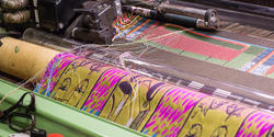 Textile being woven on loom