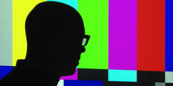 Silhouette of male in front of the Emergency Broadcast System colored bars