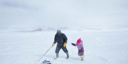 Darcy Enoogoo pulls a toy snowmobile for his daughter, Alana.