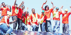 People cheering and waving up on roof with solar panels