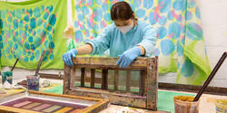 Printmaking student at work in studio wearing a mask.