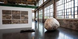large faux boulder inside a naturally lit gallery space