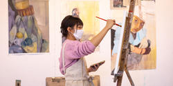 student painting at an easel
