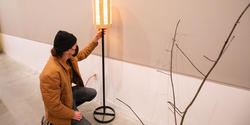 student prepares to show a standing lamp at crits