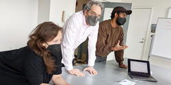 John Caserta and students gather around a table