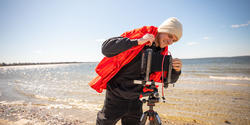 a student prepares to photograph at the beach