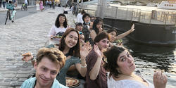 students perch near a river in Paris