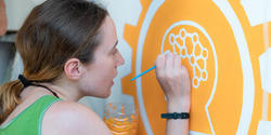 Jasmine Gutbrod painting a mural