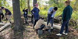 students dig holes for footings at Tillinghast Farm