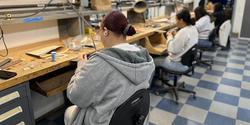 Students and work at benches in a RISD jewelry and metalsmithing studio