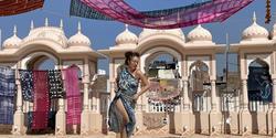 a student dancing in the sunlight with textiles above