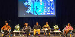 panelists on stage with an image of King behind them