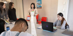 a student presents a project on a long scroll of paper