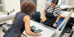 printmaking faculty member Juana Estrada Hernandez works with a student