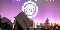 mortaboard in foreground and RISD seal in background at Commencement 2024