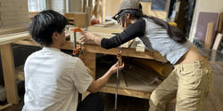 two students work together in the BEB wood shop to glue up a jig