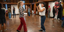 Students stand facing each other in a classroom as they play a game