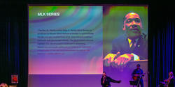 a jazz band performs in front of a portrait of Dr. King