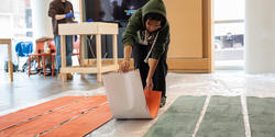 a RISD student lays out long strips of painted paper