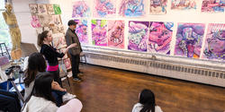 a student presents a series of pink, sparkly drawings inspired by magazine ads