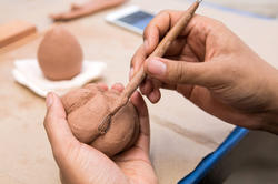 Hands working on clay piece