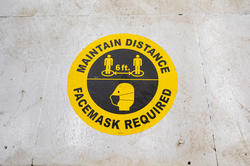 "Maintain distance, facemask required" signage