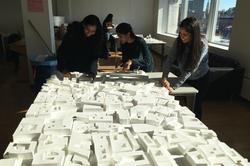 Interior Architecture students look at structural models on a long table