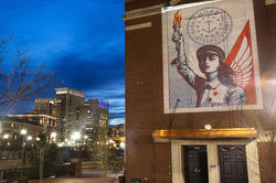 An artwork by Shepard Fairey titled RI Angel of Hope and Strength projected onto the RISD Auditorium exterior at night in downtown Providence