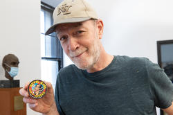 Bill Adler holds up a small tin of candy with a Devil Girl comic on the lid