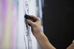 close-up image of a hand drawing in charcoal