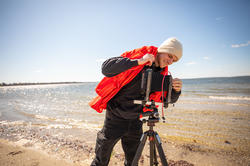 a student prepares to photograph at the beach