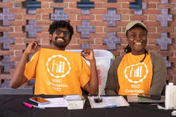 Two orientation leaders smile at the camera on move in day