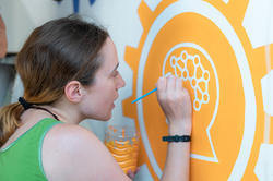 Jasmine Gutbrod painting a mural