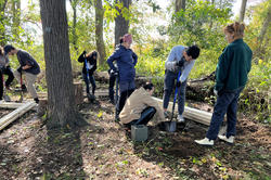students dig holes for footings at Tillinghast Farm