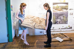 Two students holding landscape model.