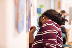 close up of student painting against a studio wall