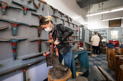 Jewelry student working at anvil.