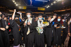 a group of graduating seniors celebrate in a full audience