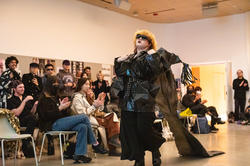 A student struts down the runway as peers cheer on the sidelines