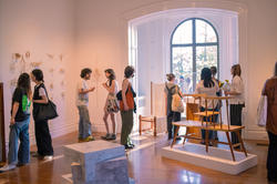 students mingle in woods-gerry gallery surrounded by student work