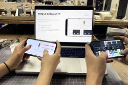 Students hold up their phones, demonstrating a web based synthesizer they made